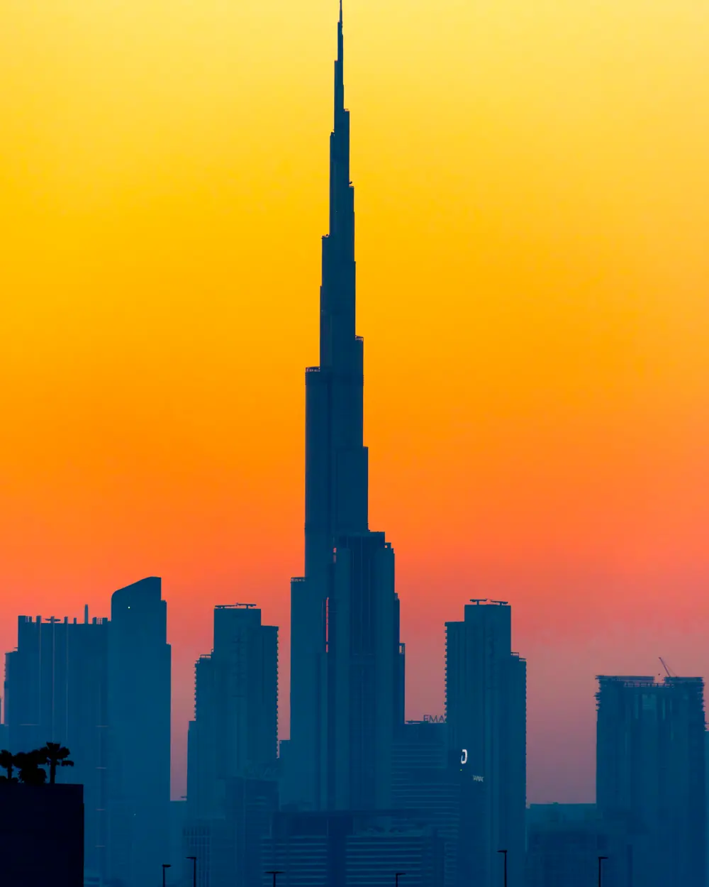 Dramatic silhouette of Burj Khalifa at sunset with vibrant orange sky