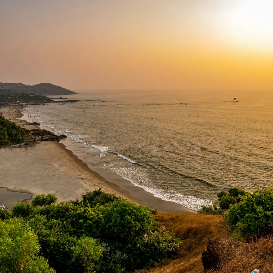 the sun is setting over the ocean and a beach
