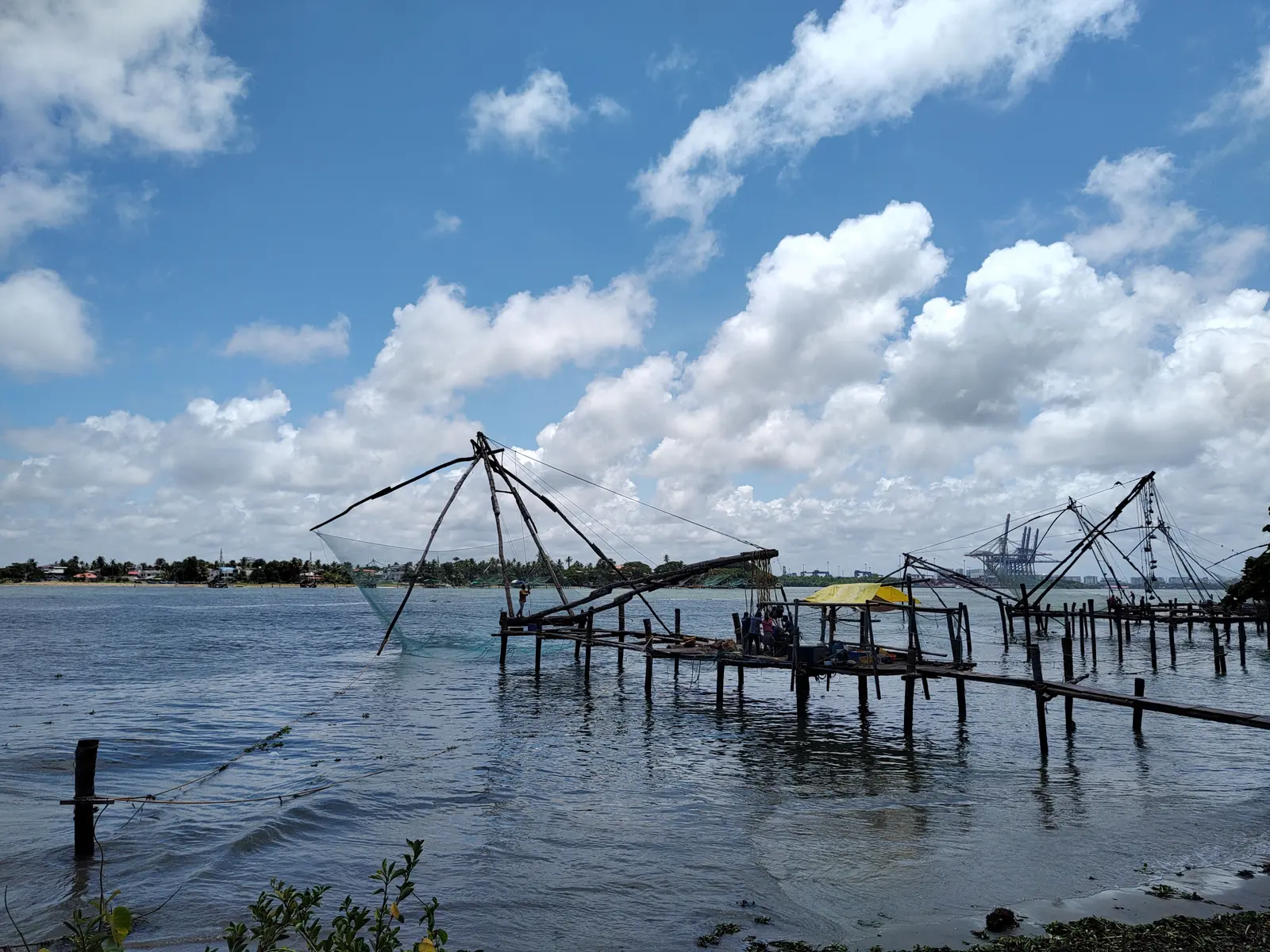 Chinese fishing nets on the water at Fort Kochi under a blue sky
