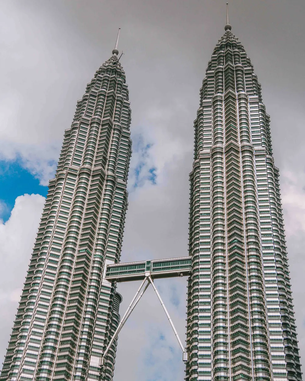 A stunning view of the iconic Petronas Towers against a cloudy sky in Kuala Lumpur, Malaysia