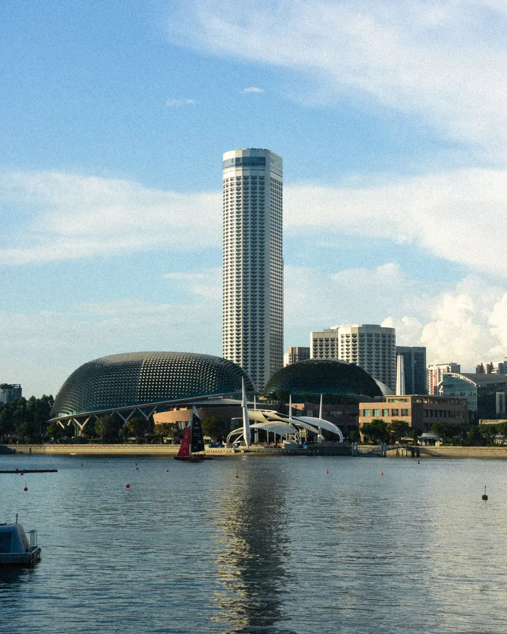 A stunning view of Singapore's Marina Bay featuring the iconic Esplanade and city skyline under a clear sky