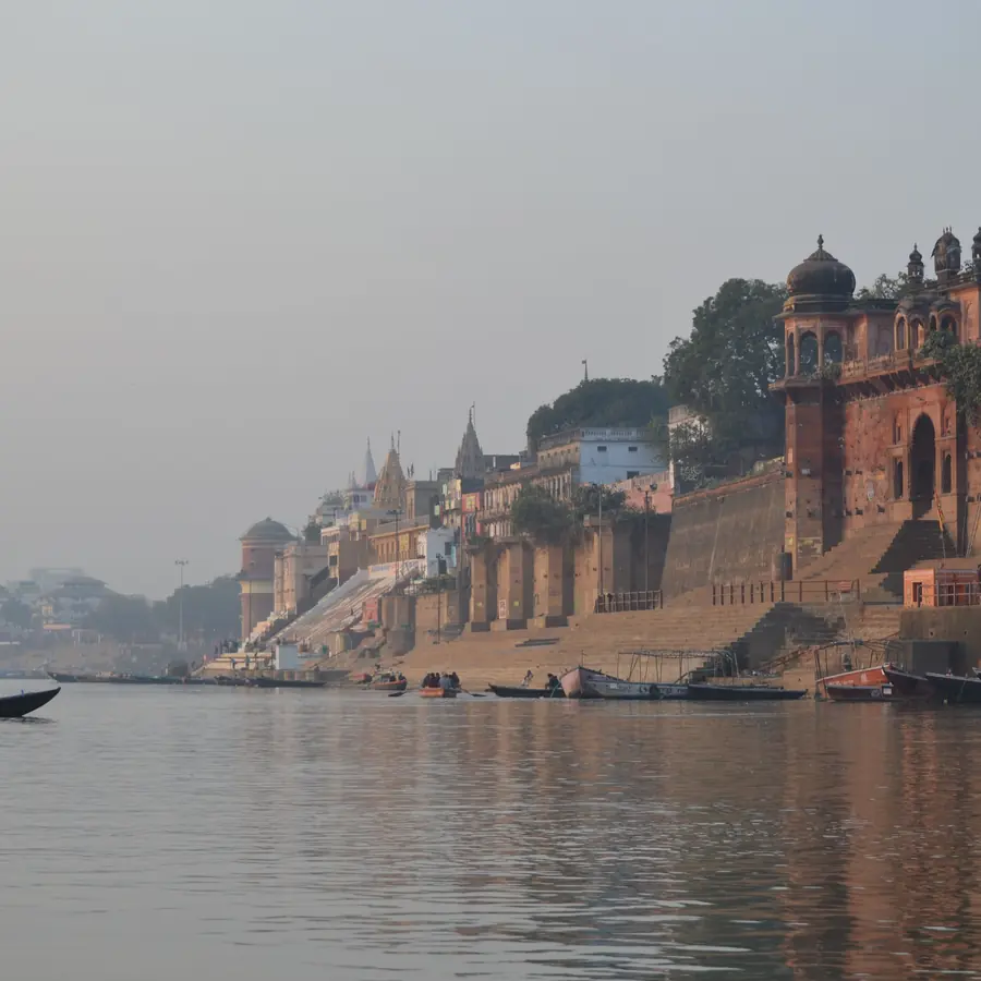 Serene morning at Varanasi Ghats with a boat sailing on the Ganges River