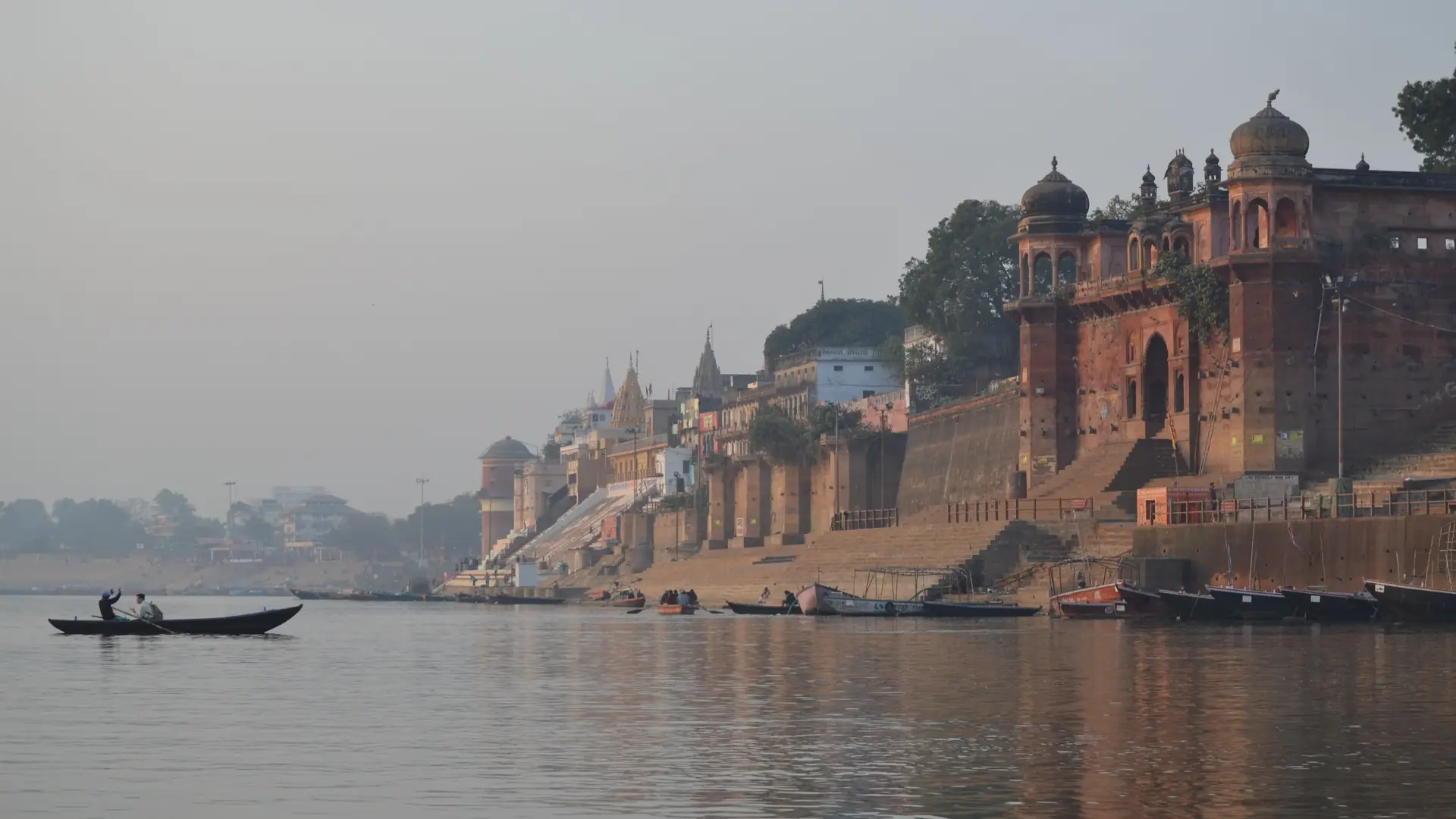 Serene morning at Varanasi Ghats with a boat sailing on the Ganges River